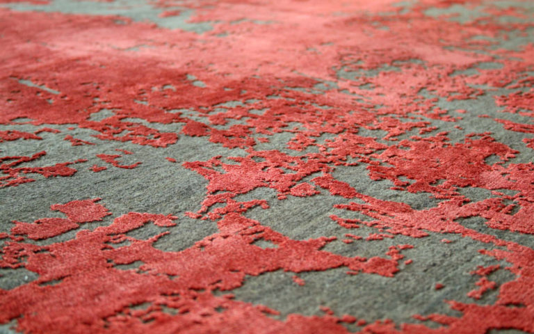 Dark grey and red designer rug with raised textured pattern