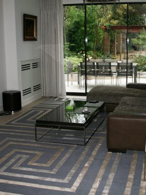 geometric modern rug with silk in room with brown leather sofa