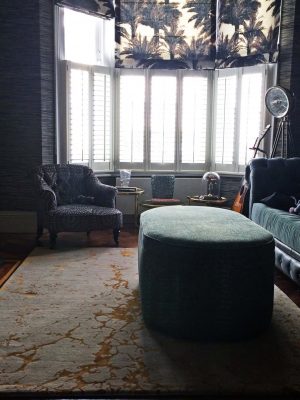 wool and silk luxury rug in living room with green velvet sofa dark and moody