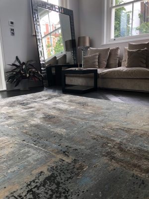 luxury blue abstract rug with neutral sofa