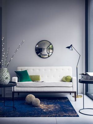 blue and copper abstract rug with white sofa