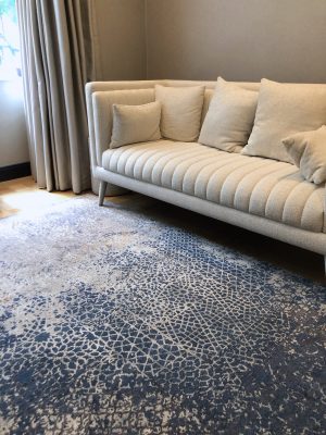 blue luxury rug in living room with cream sofa